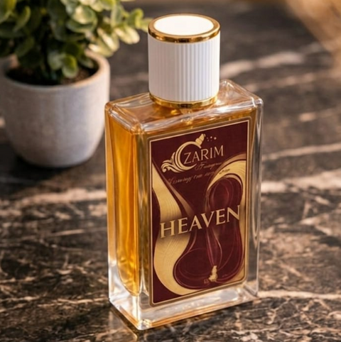 Perfume bottle labeled 'Heaven' by 'Ozarim' on a marble surface with a plant in the background.
