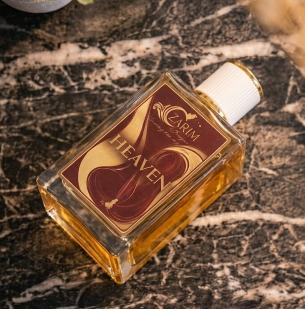 Small bottle of Oud on a marble surface with a plant in the background