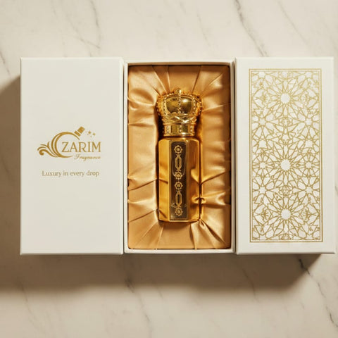 Gold perfume bottle in a decorative box with 'Zarim' branding on a marble surface.
